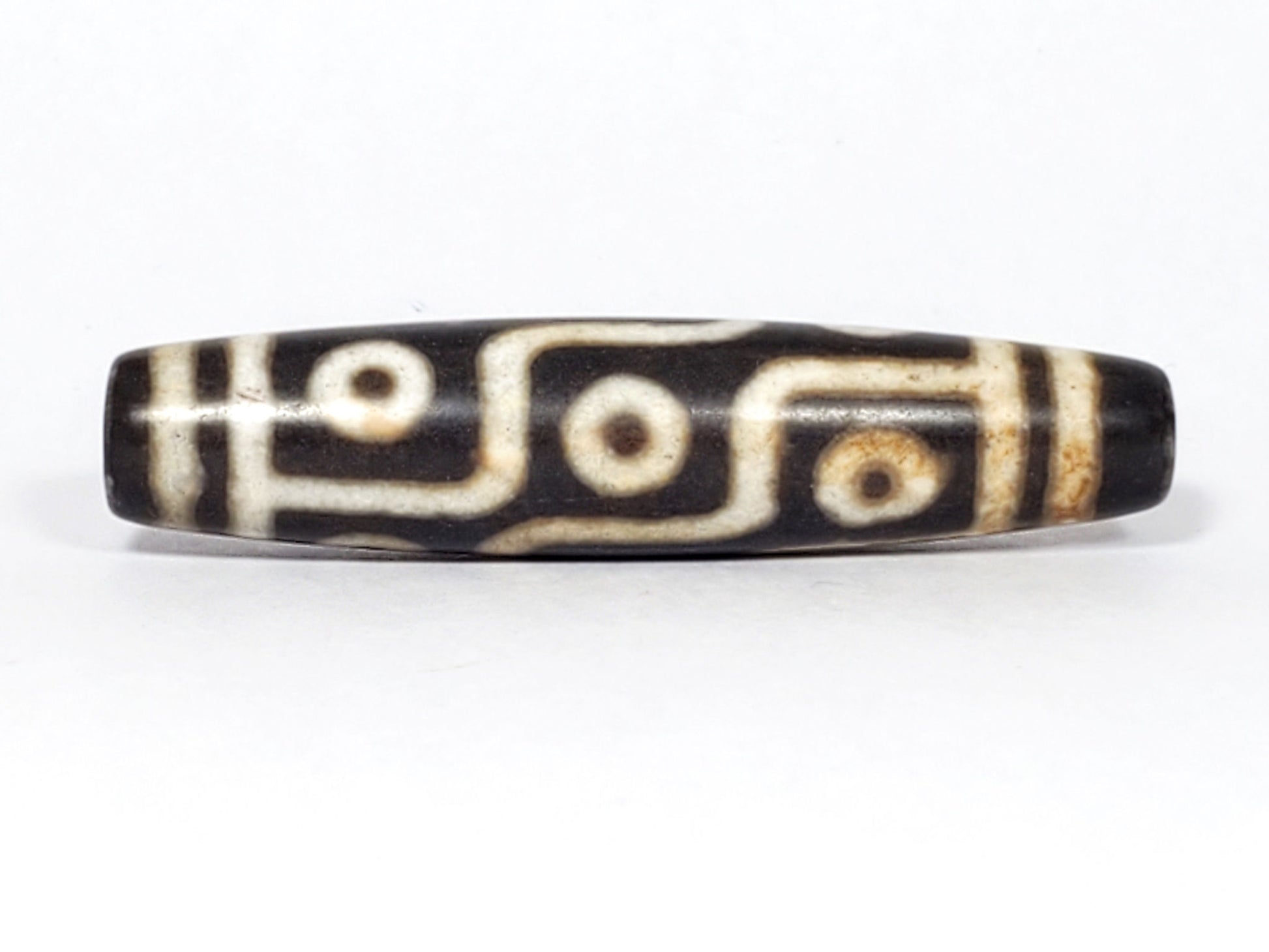 N-062226-9E2, nine eye agate dzi, 57.3×13.0mm, very dark warm brown, warm cream motif, face A, unretouched