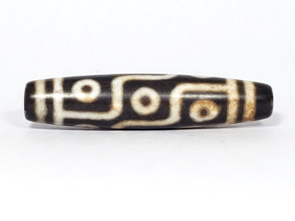 N-062226-9E2, nine eye agate dzi, 57.3×13.0mm, very dark warm brown, warm cream motif, face A, unretouched