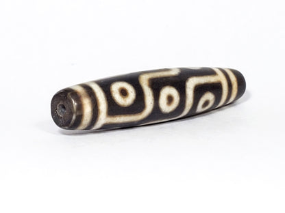 N-062226-9E2, angled view toward broader end, drill hole centred, warm cream motif visible, dark warm brown, unretouched