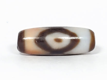 N-062226-3E, face B, lens-shaped eye, bright white ground zone, dark brown ring, honey-tan interior, unretouched