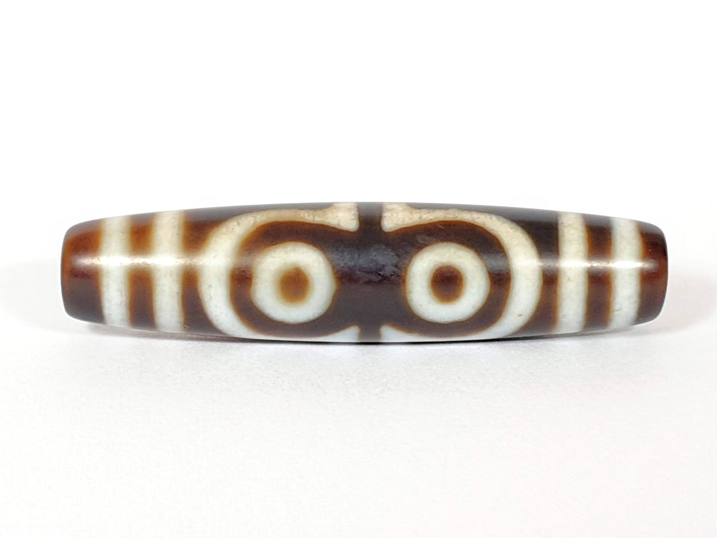 N-062426-4E new four eye dzi 58.5x13.9mm Face B two closed-ring eyes connected at centre warm brown agate unretouched