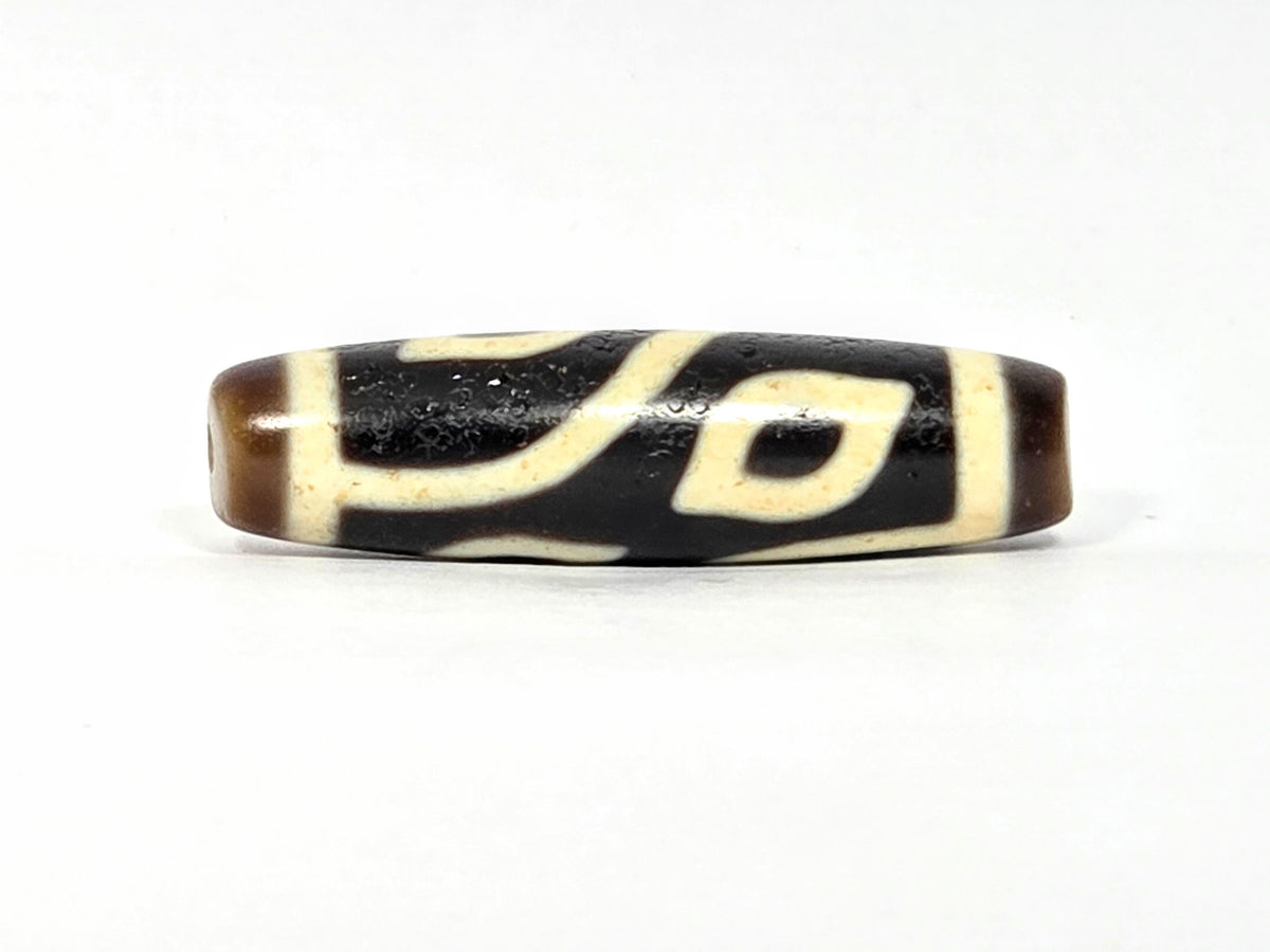 Four-eye dzi bead in dark brown and black agate with cream striping, 40.2mm