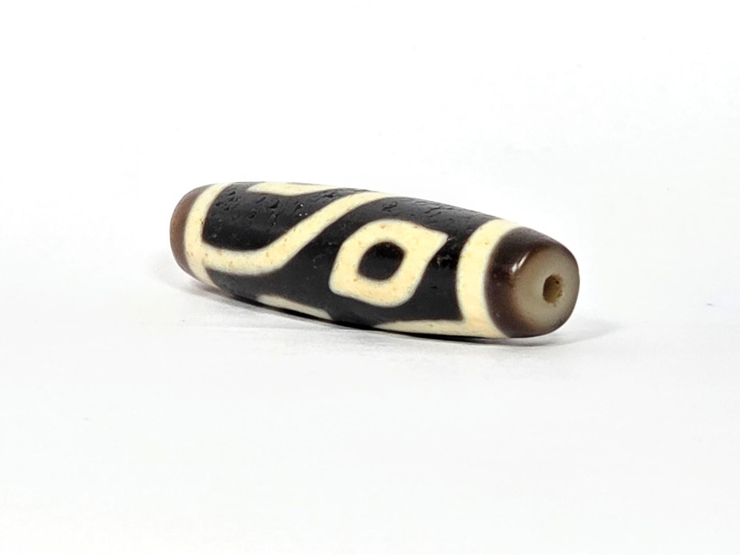 N-090225-4E2 angled drill-end view, dark brown end cap, eye visible near drilling, unretouched