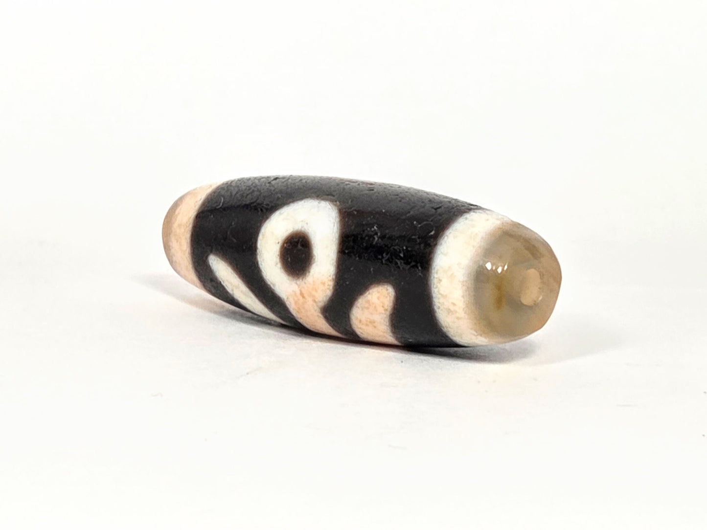 N-070526-BenBS angled drill-end view, benefactor dzi, glossy grey-green end cap, agate body, unretouched