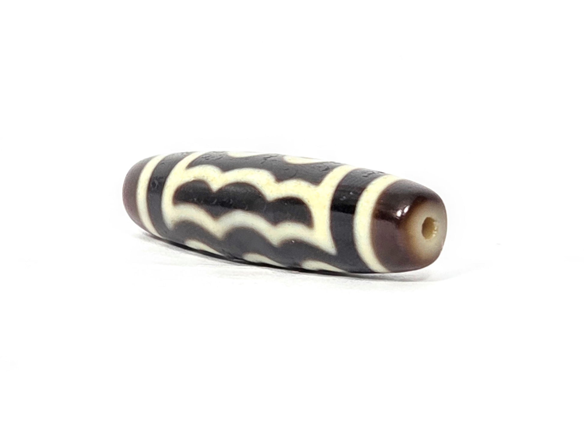 N-091125-5E2 angled drill-end view, warm honey-brown end cap, wave pattern wraps end, very dark brown agate, unretouched