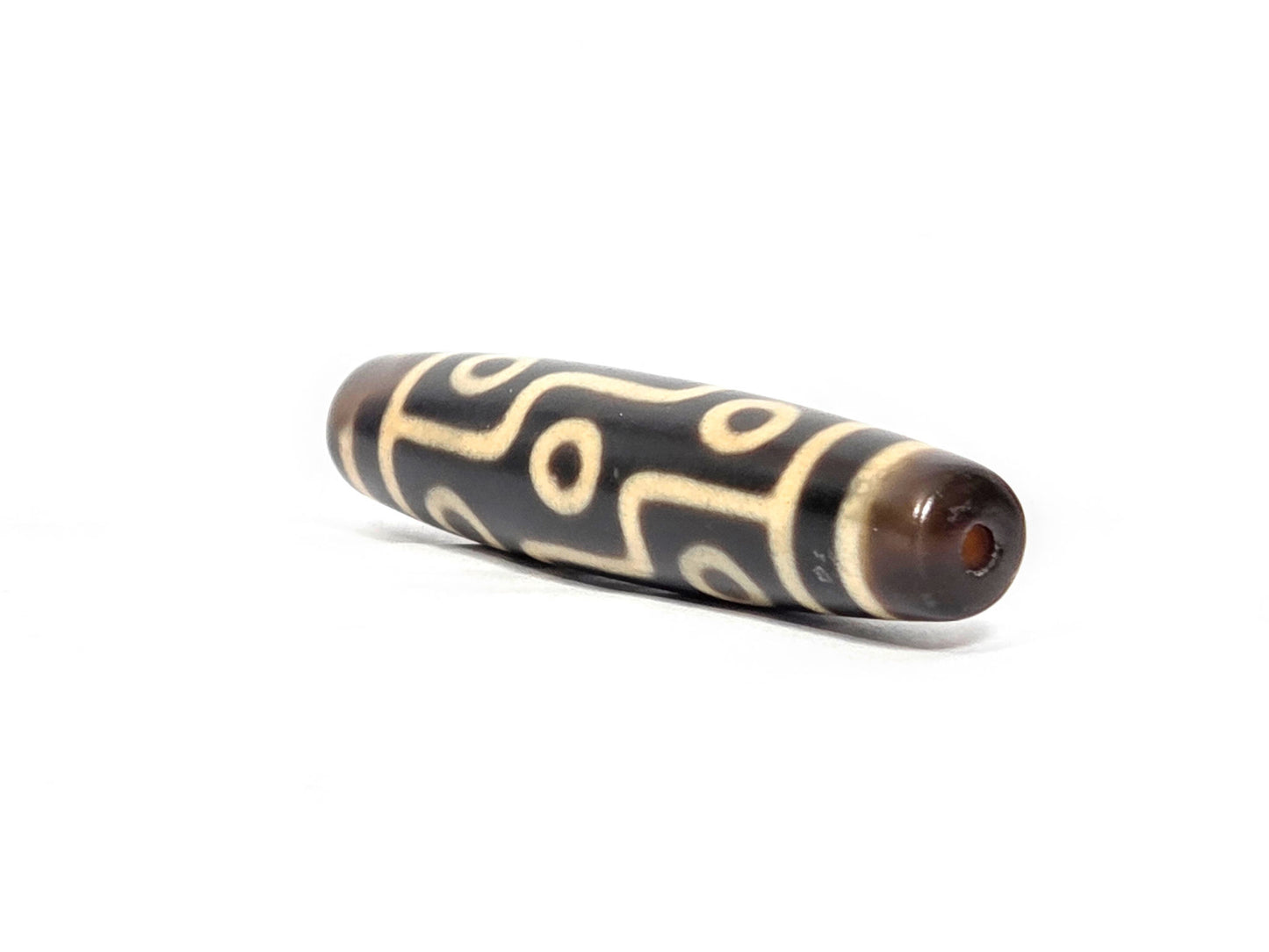 N-122225-9E Nine Eye dzi bead, angled end view, warm reddish-brown end cap visible, unretouched
