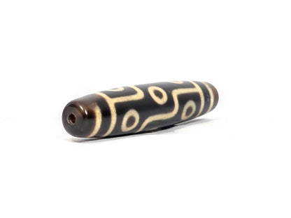 N-122225-9E Nine Eye dzi bead, opposite angled end view, drill channel and reddish-brown cap, unretouched