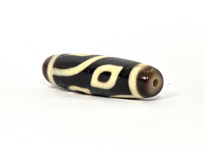 N-082825-4E angled drill-end view, dark brown end cap, eye visible near drilling, unretouched