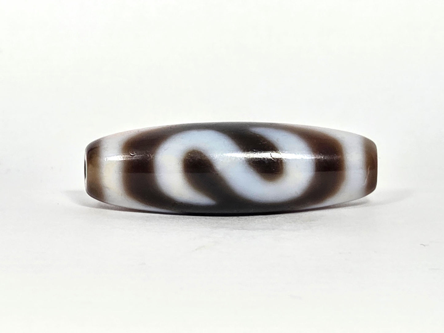 N-070526-MHkBS rotated face 3, money hook dzi, very dark brown ground, S-curve hook form, cream lines, unretouched