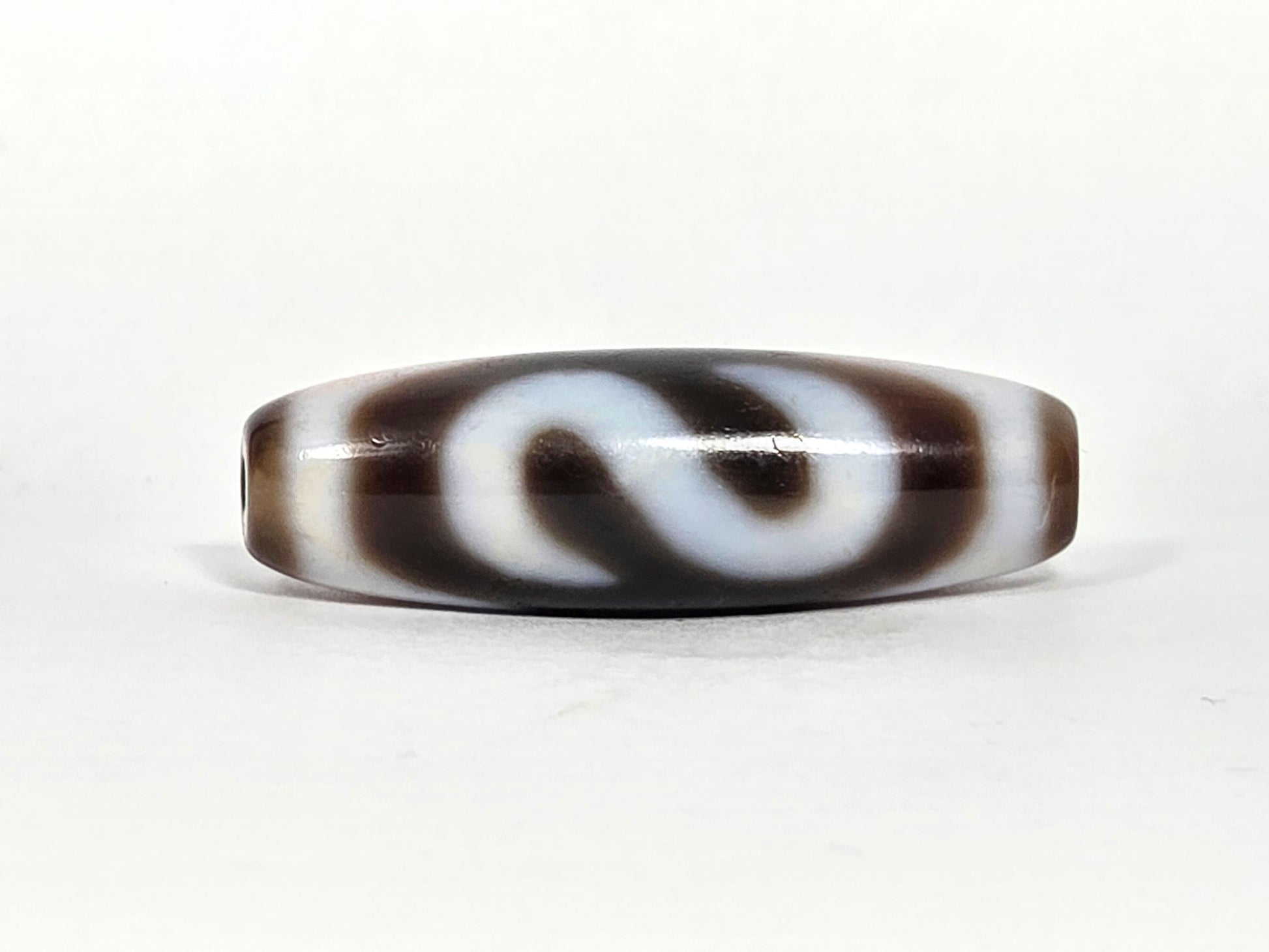 N-070526-MHkBS rotated face 3, money hook dzi, very dark brown ground, S-curve hook form, cream lines, unretouched