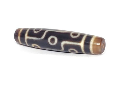 N-102123-9E Nine Eye dzi bead, angled end view, honey-brown end cap, unretouched