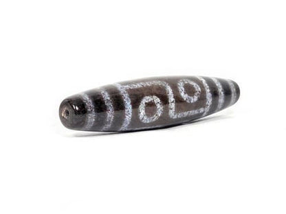 N-062126-6E dzi bead, three-quarter angle showing drilled end, unretouched