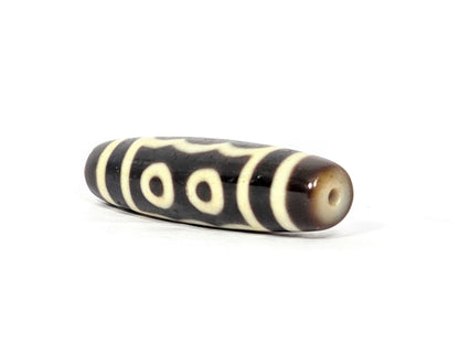 N-091025-5E angled drill-end view, warm honey-brown end cap, two-eye face visible, very dark brown agate, unretouched