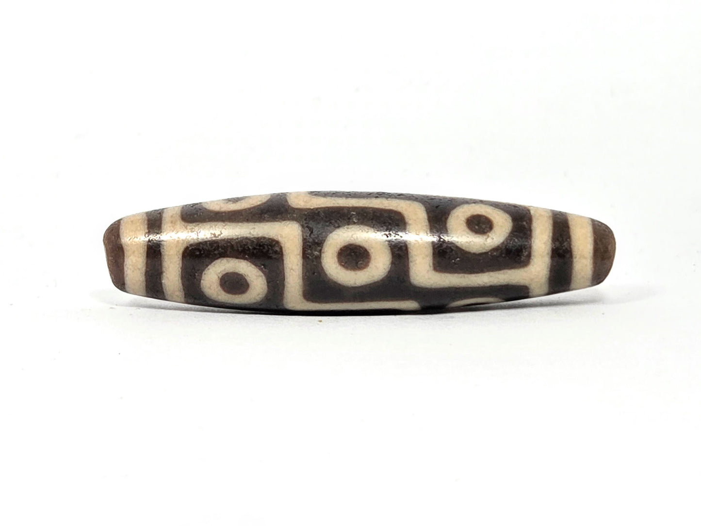Ac-032326-9E5 ancient nine eye dzi 53.1×12.8mm Face A, warm dark brown ground, broad cream-white eyes, unretouched