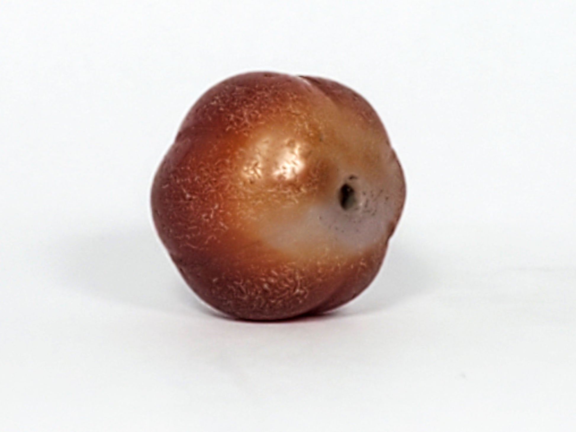 Ac-061126-PKP Bead B angled drill hole end, golden-brown zone with natural banding, weathered bore, unretouched