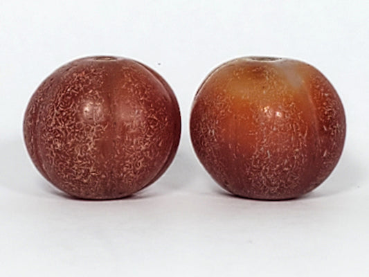 Ac-061126-PKP hero pair, reddish-brown Bead A left, honey-brown Bead B right, ribbed pumpkin form, unretouched