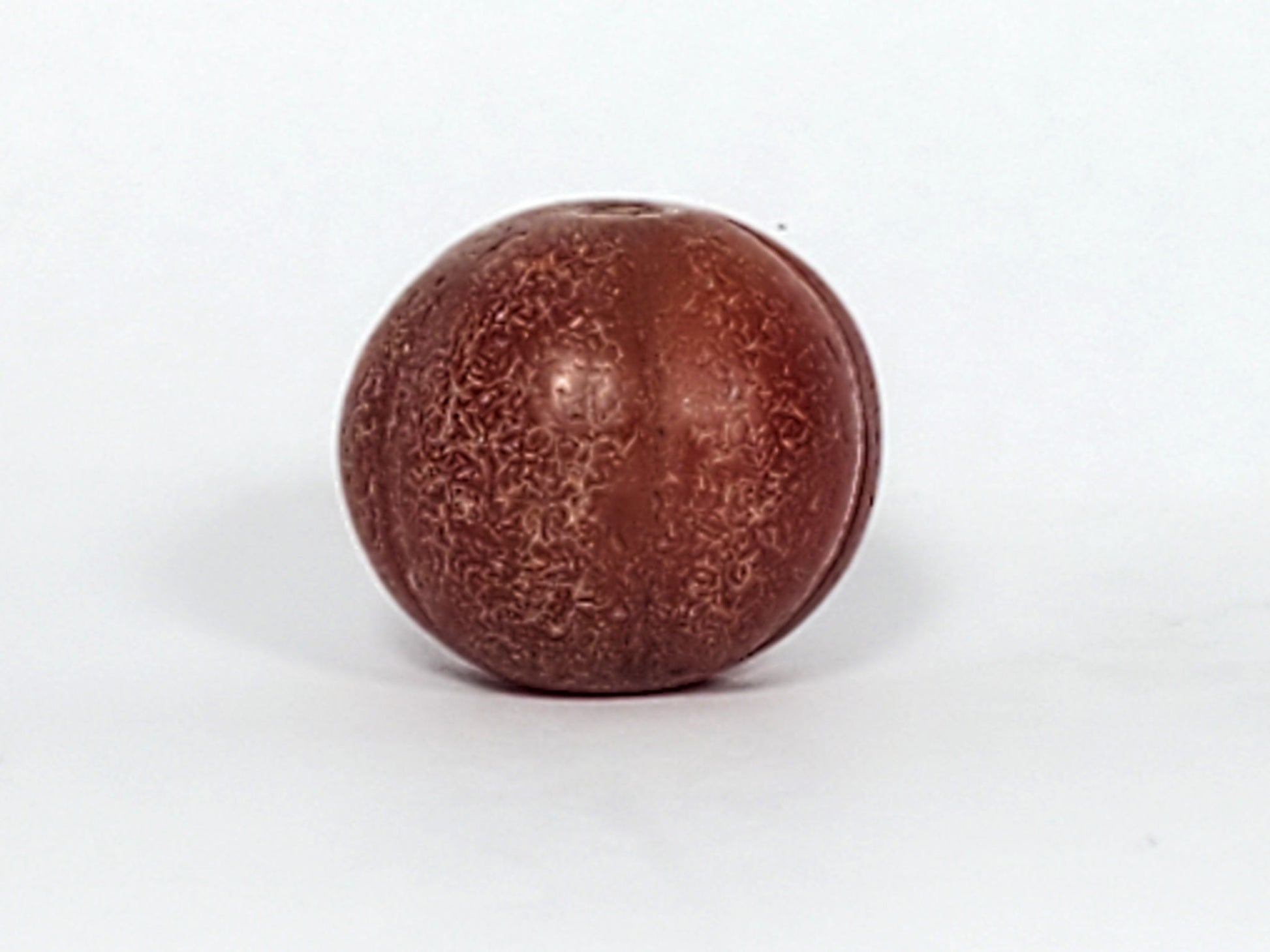 Ac-061126-PKP Bead A front, deep reddish-brown carnelian, dense crackle texture on lobe valleys, ribbed form, unretouched