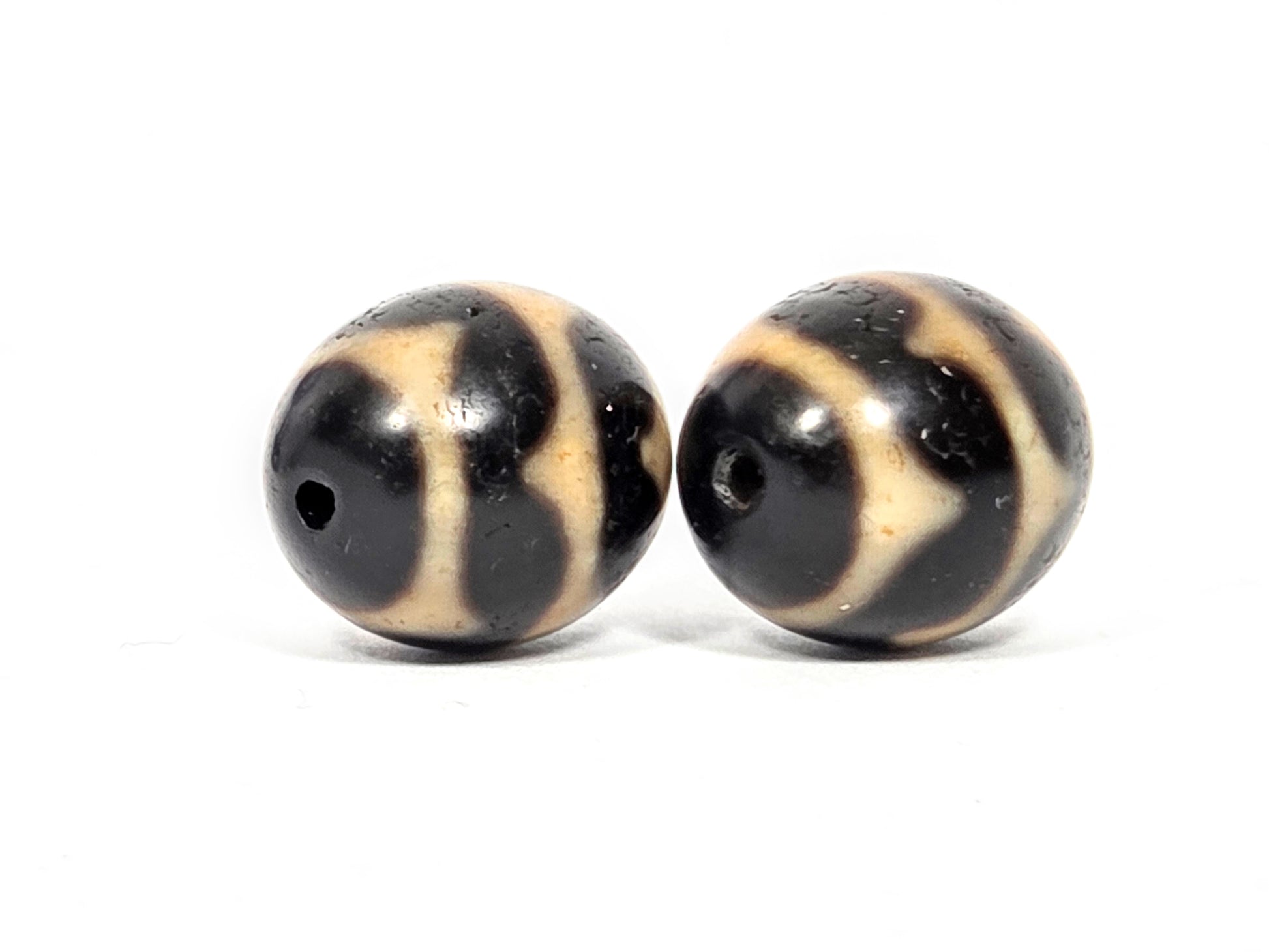 Vintage Taiwan 1980s round dzi bead pair, angled view showing depth and quality of Double Wave motif etching