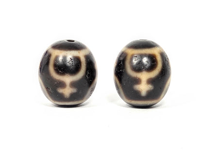 Pair of round Treasure Vase Dzi beads showing four-vase etching pattern on natural agate surface