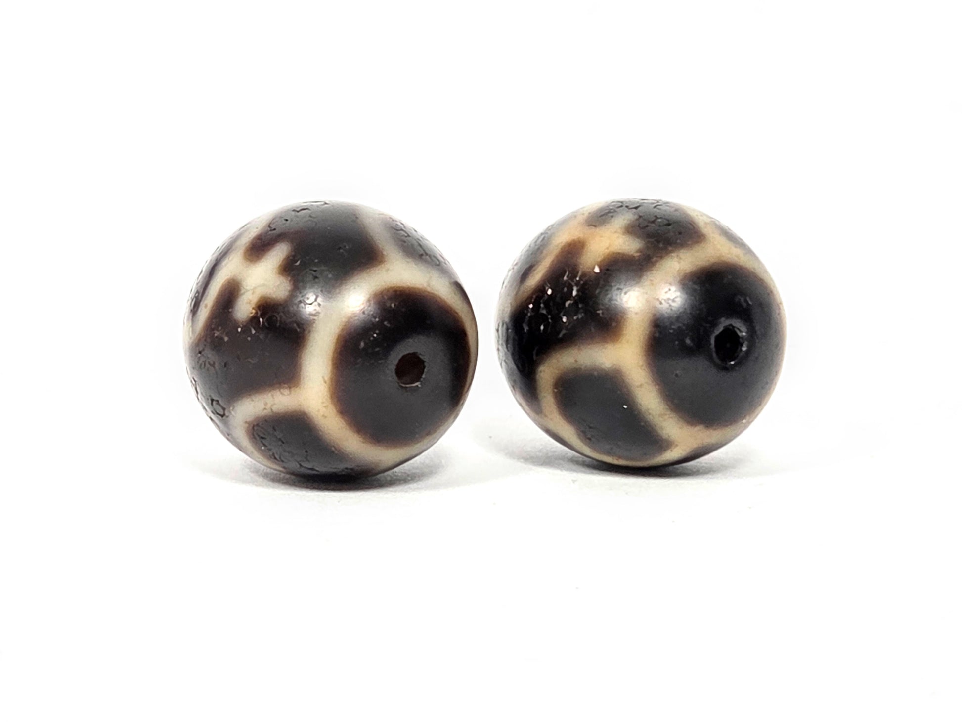 Side profile view of matched pair of round Treasure Vase dzi beads showing spherical shape and agate quality