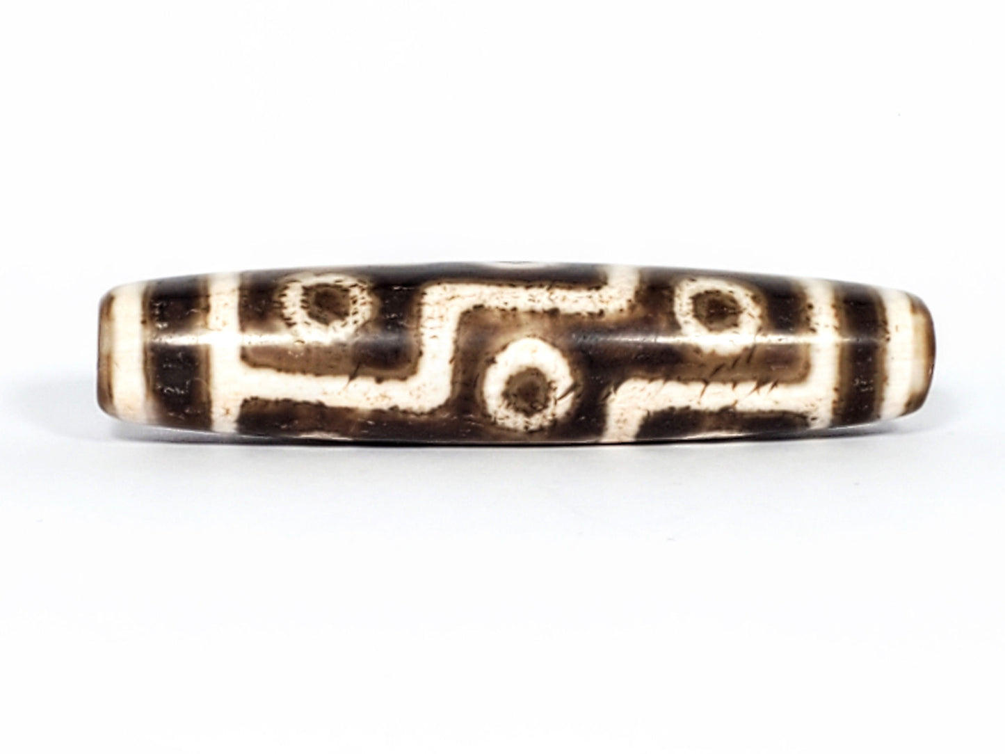 Qing Dynasty nine eye dzi — Face A, nine eye motif with S-curve connectors, dark ground, granular cream zones, At-0426-9EQ