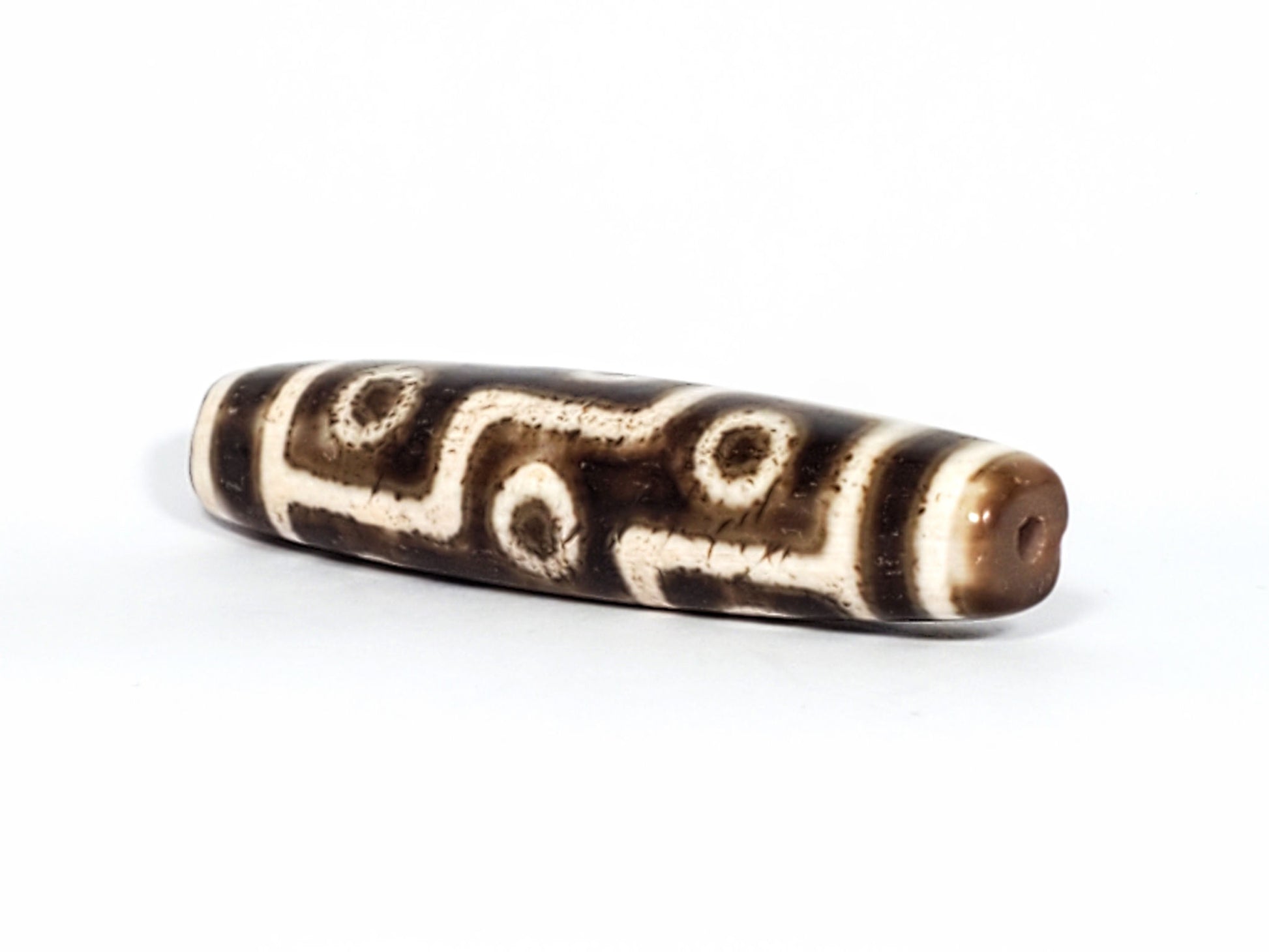 Qing Dynasty nine eye dzi — angled end, drill hole at warm brown rounded tip, S-curve and eye rings on body, At-0426-9EQ