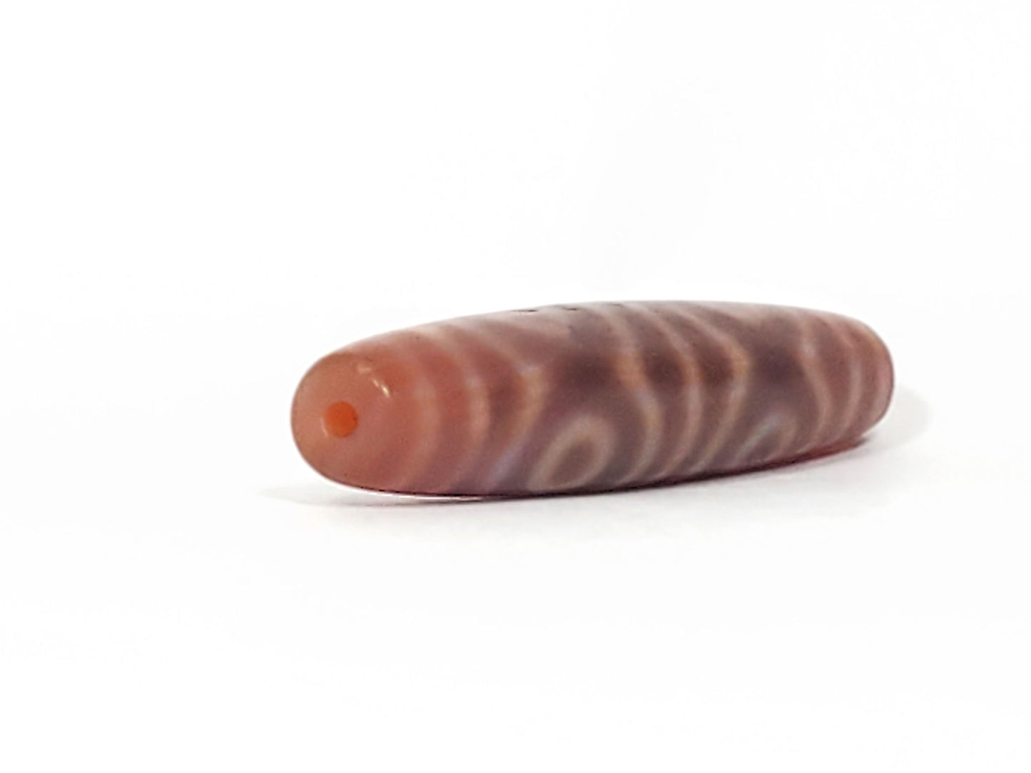 At-082624-6EBS, opposite end angled view, six concentric eyes wrapping full body, matte rose-brown agate, unretouched
