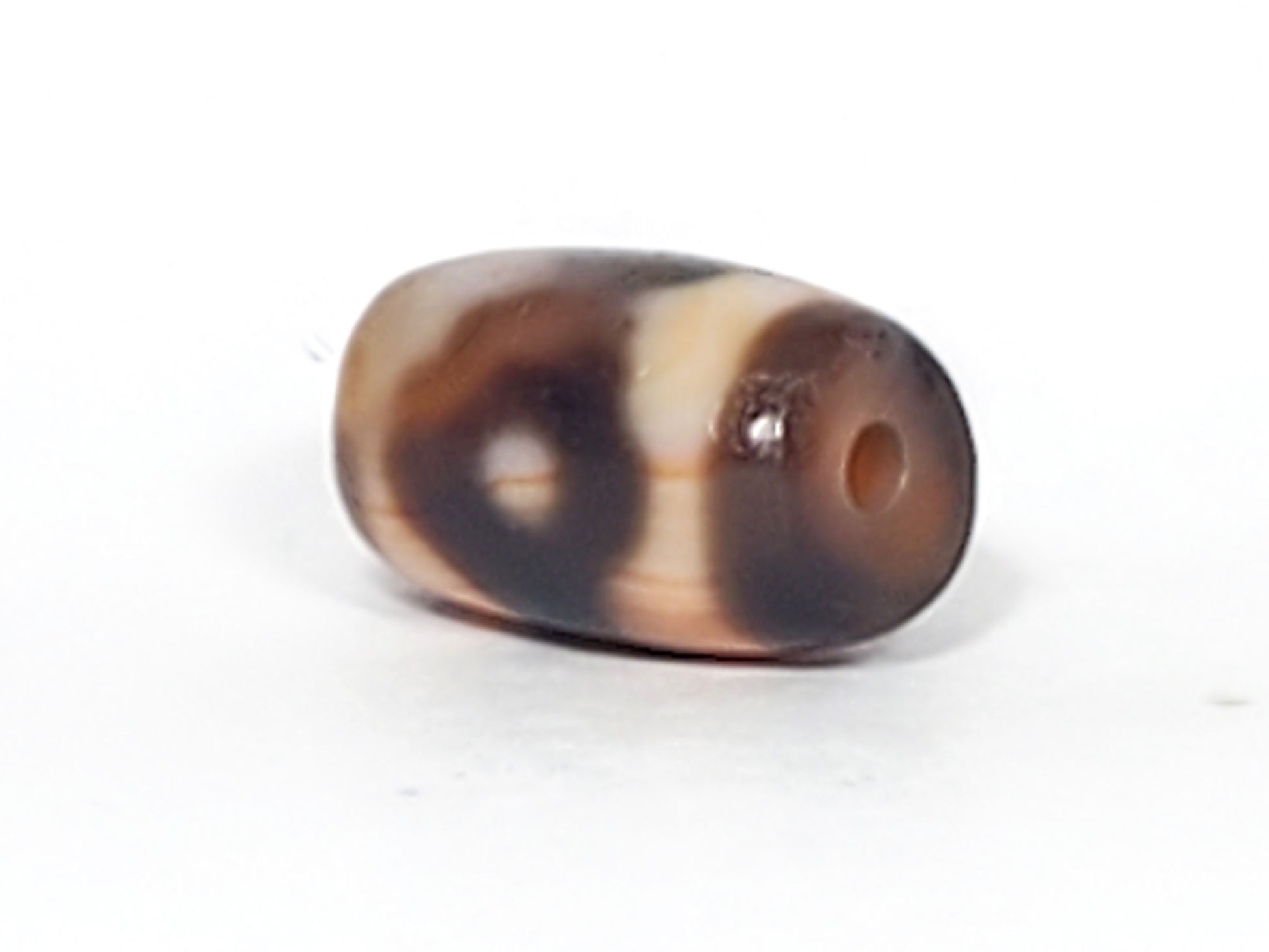 At-061926-3E2 angled view, compact rounded barrel form, peach-tan end cap, unretouched