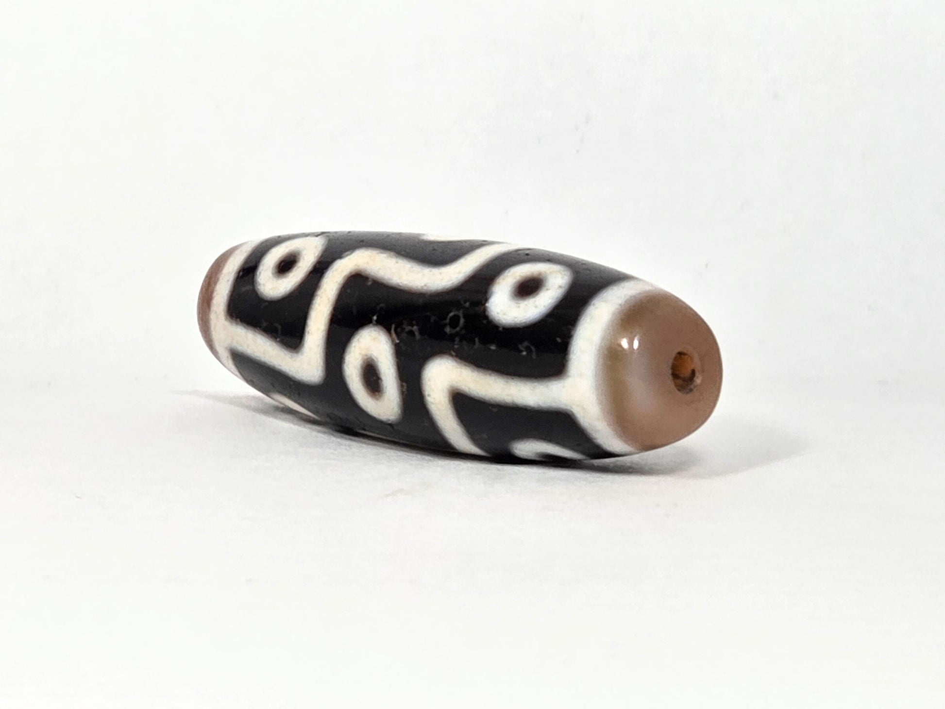 At-061926-9E6BS angled tip B, warm sandy-tan end cap, small drill hole, compact form visible, unretouched