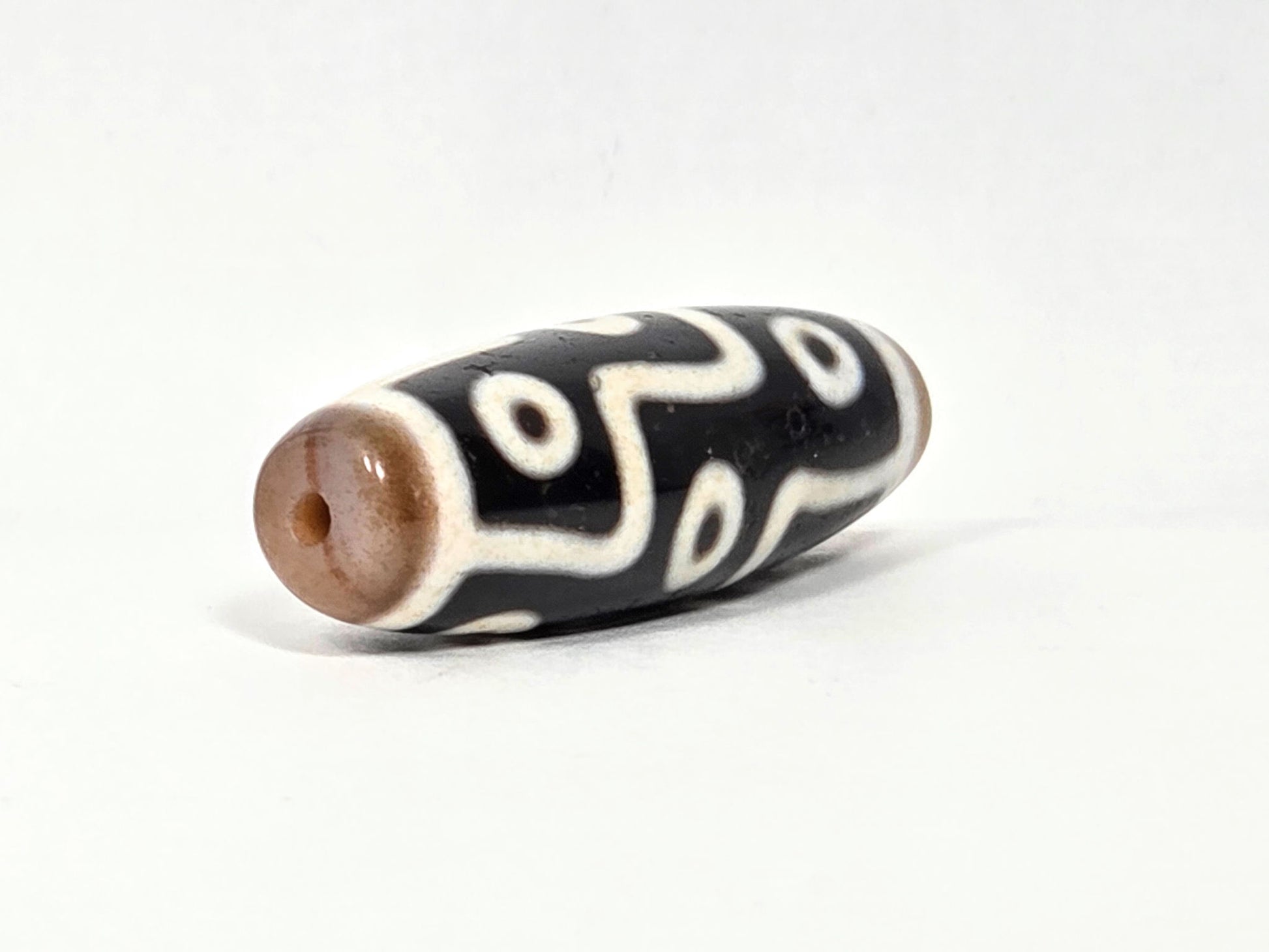 At-061926-9E6BS angled tip A, warm sandy-tan cap, reddish-brown drill interior, wide barrel form, unretouched