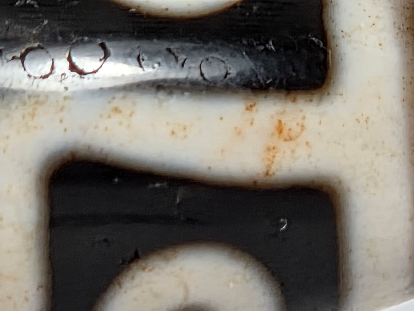 At-061926-9E6BS macro, dark red cinnabar halo inclusions in pitch-black ground zone, unretouched