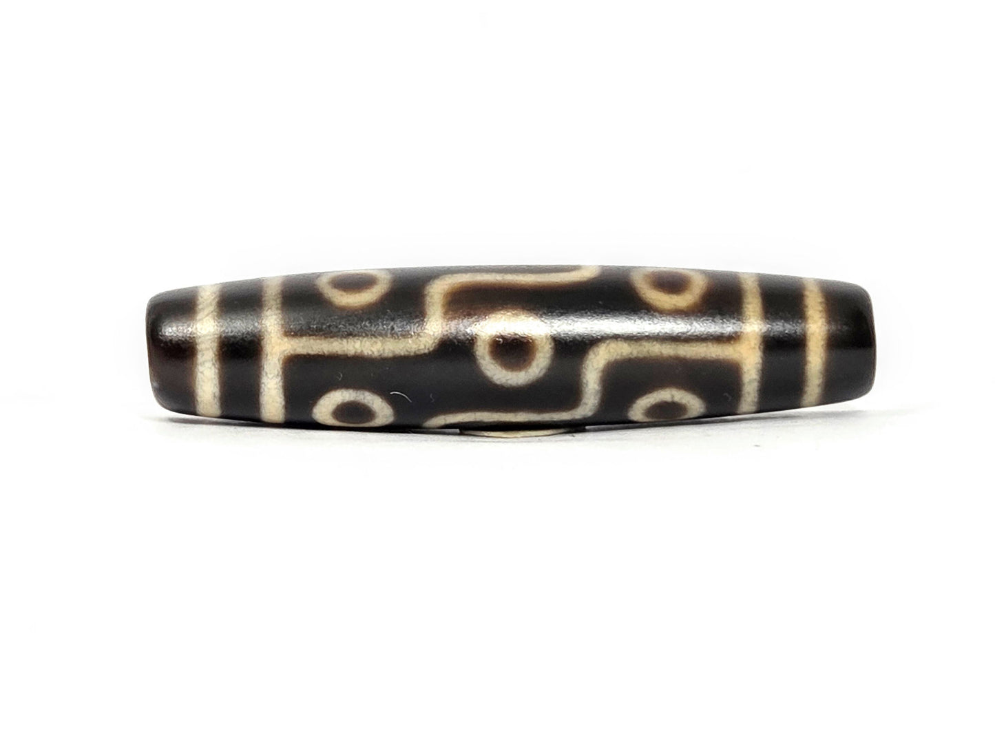 N-122325-9E Nine Eye dzi bead, alternate front angle, deep dark brown ground, cream motif lines, unretouched