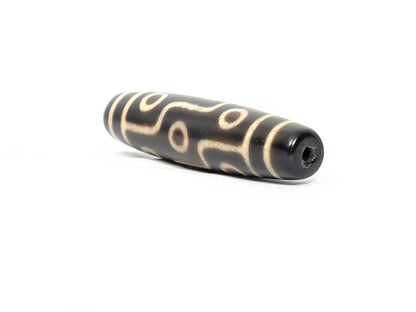 N-122325-9E Nine Eye dzi bead, angled end view, uniform dark brown end cap, drill channel visible, unretouched