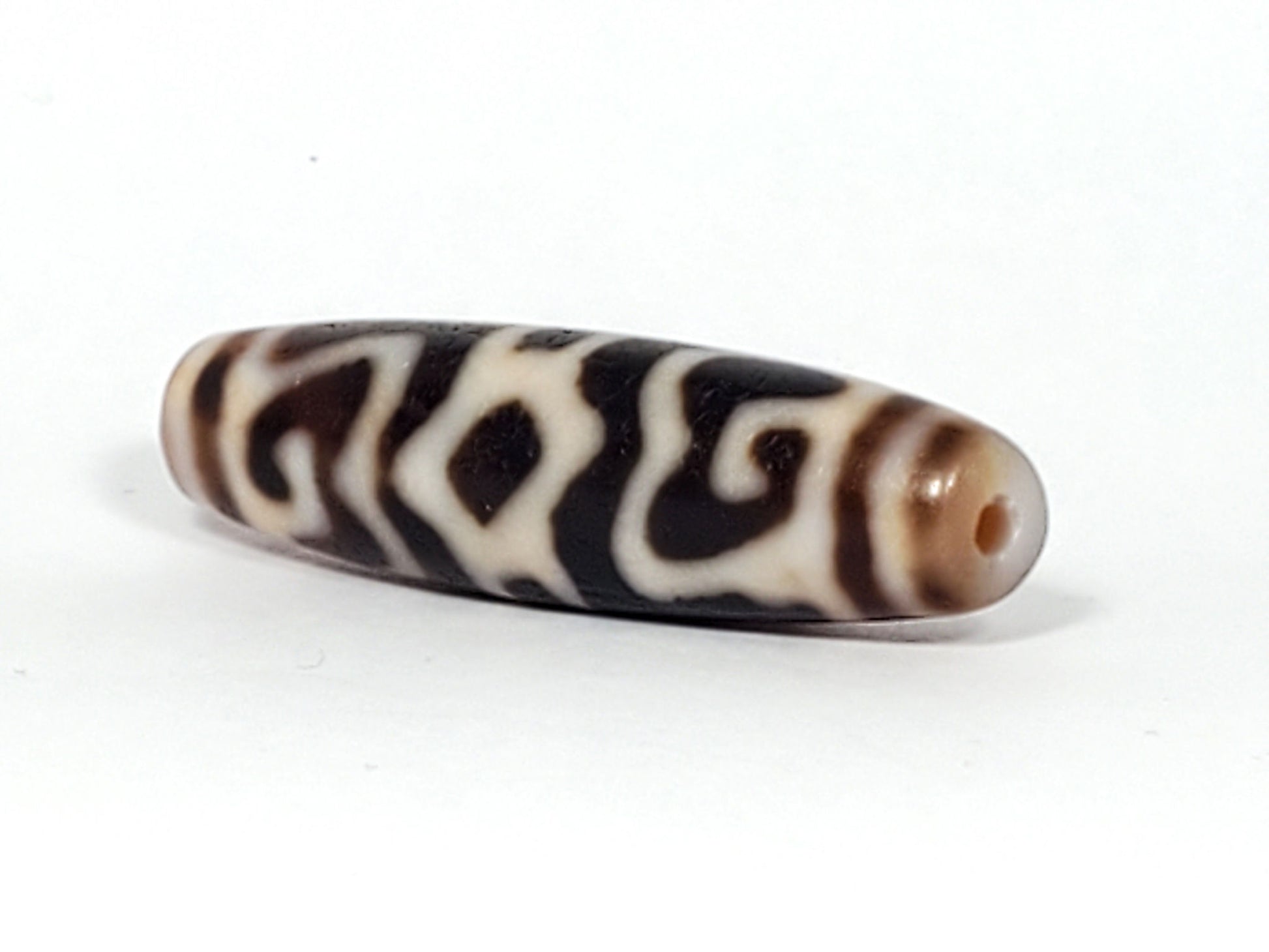 Ac-061926-GRDC angled tip B, diamond lozenge voids, dense cream-white motif, honey-brown end cap, unretouched
