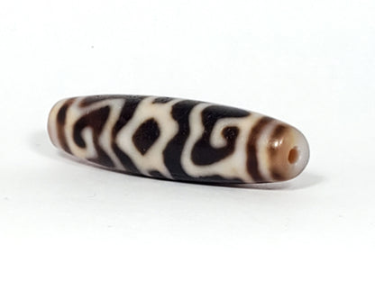 Ac-061926-GRDC angled tip B, diamond lozenge voids, dense cream-white motif, honey-brown end cap, unretouched