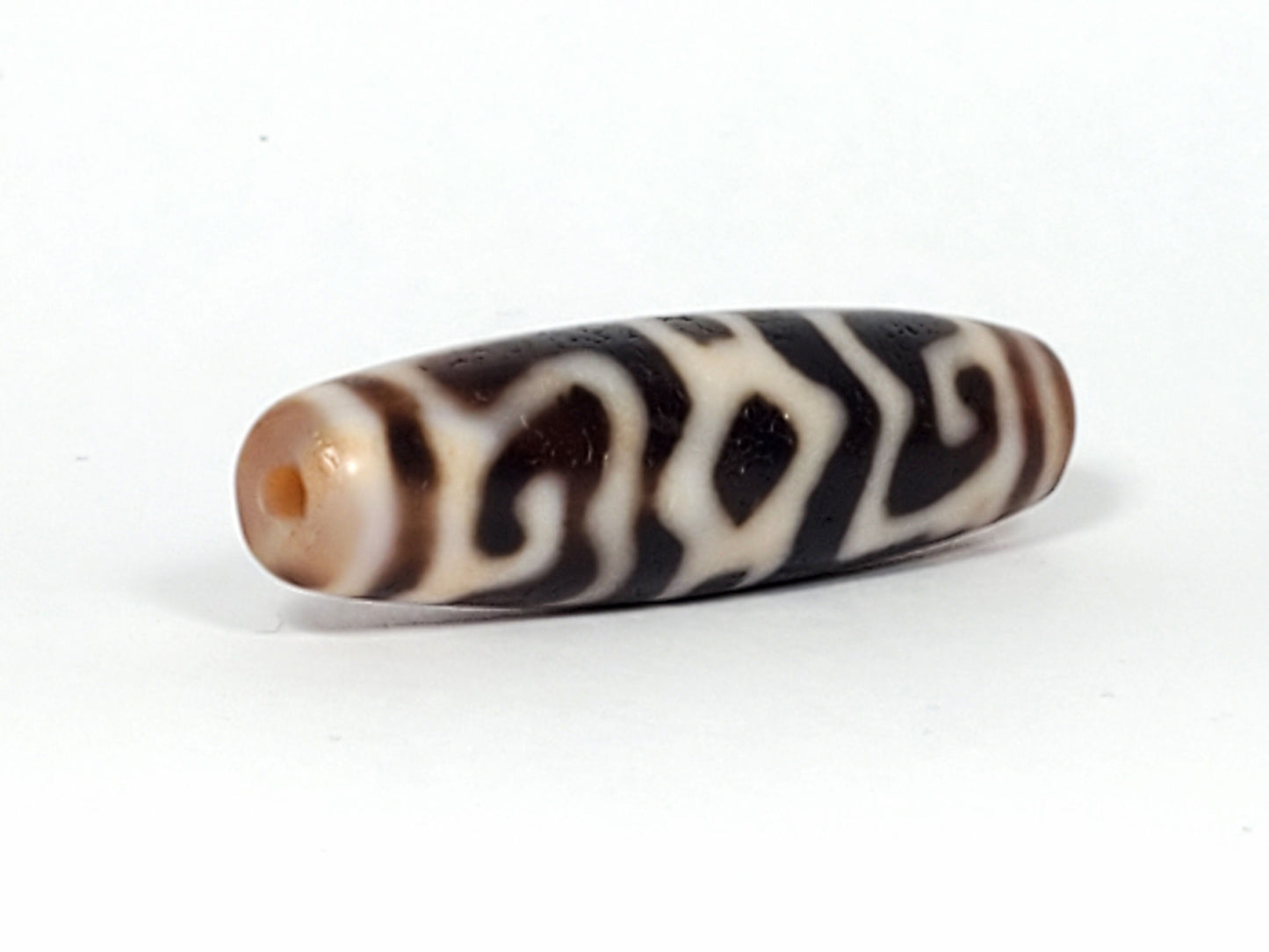 Ac-061926-GRDC angled tip A, elongated fusiform form, honey-brown cap, small drill hole, unretouched