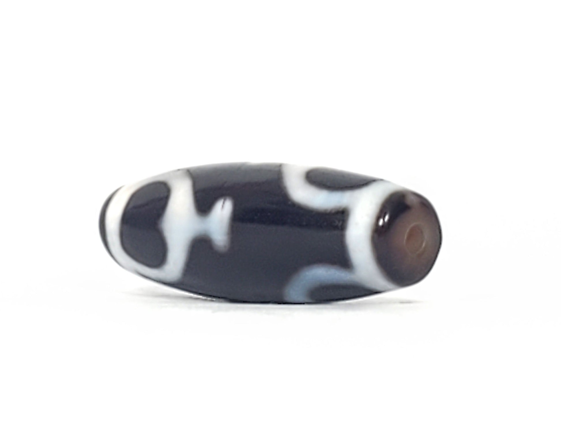 V-092224-TrVBS dzi bead, diagonal view showing drill hole, black agate, unretouched photo.