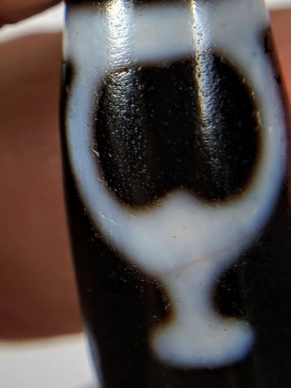 V-092224-TrVBS dzi bead, macro view of vase motif showing cinnabar bloodspot inclusions, unretouched.