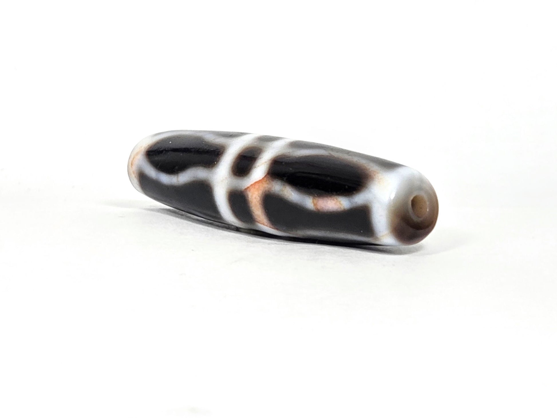 V-070526-3VjBS angled drill-end, triple vajra dzi, warm grey-beige end cap, dark agate body, unretouched