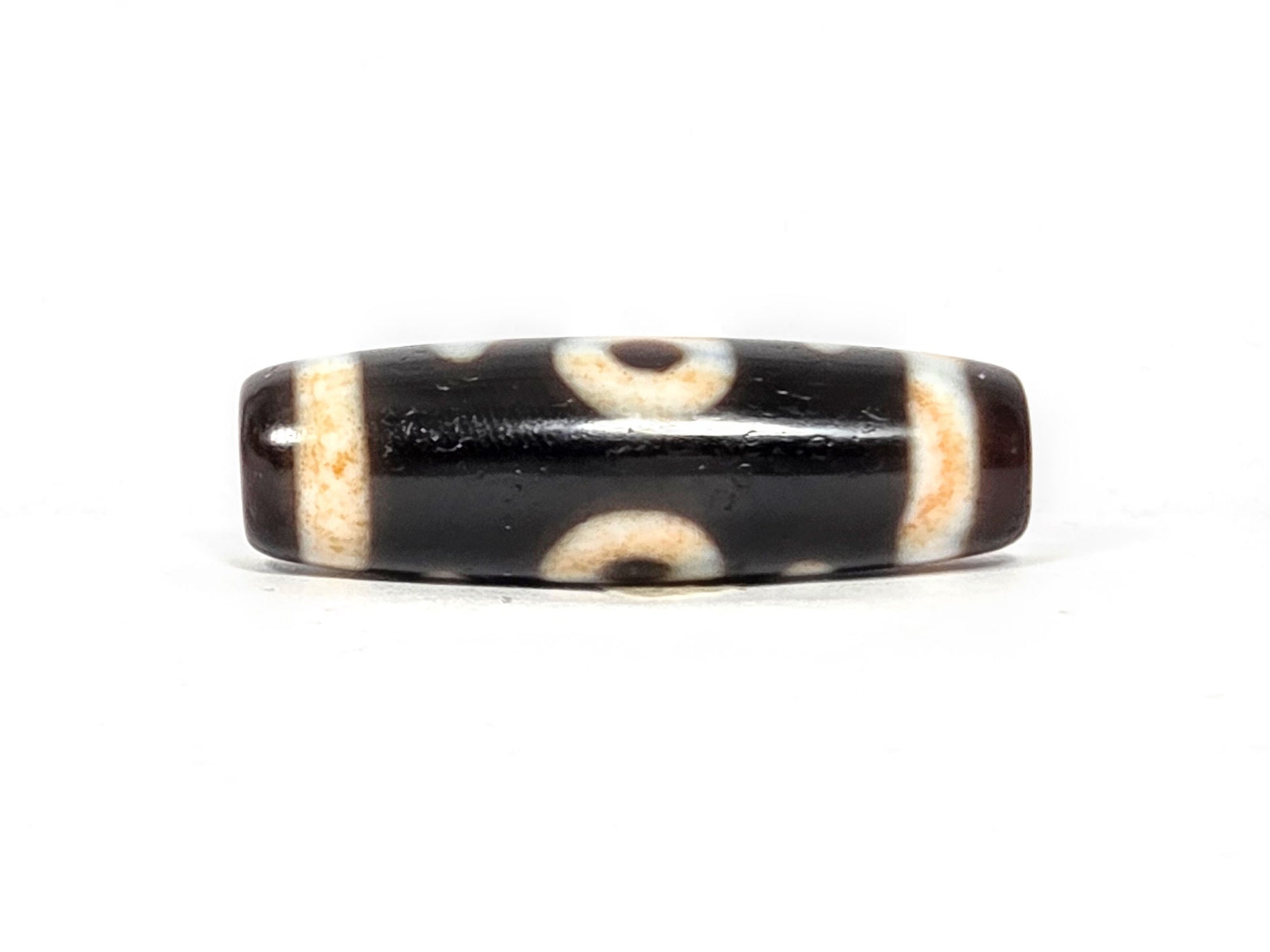 V-021326-BenBS Benefactor dzi bead, fourth face, cream-dark composition, pitch-black and dark brown zones, unretouched.