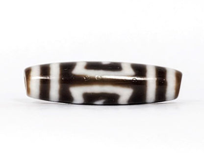 V-091424-GarudaBS Garuda dzi bead, fourth face angle, horizontal motif composition, dark brown ground, unretouched