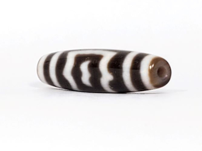V-091424-GarudaBS Garuda dzi bead, angled end view, warm honey-tan end cap and drill hole visible, unretouched