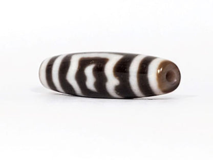 V-091424-GarudaBS Garuda dzi bead, angled end view, warm honey-tan end cap and drill hole visible, unretouched