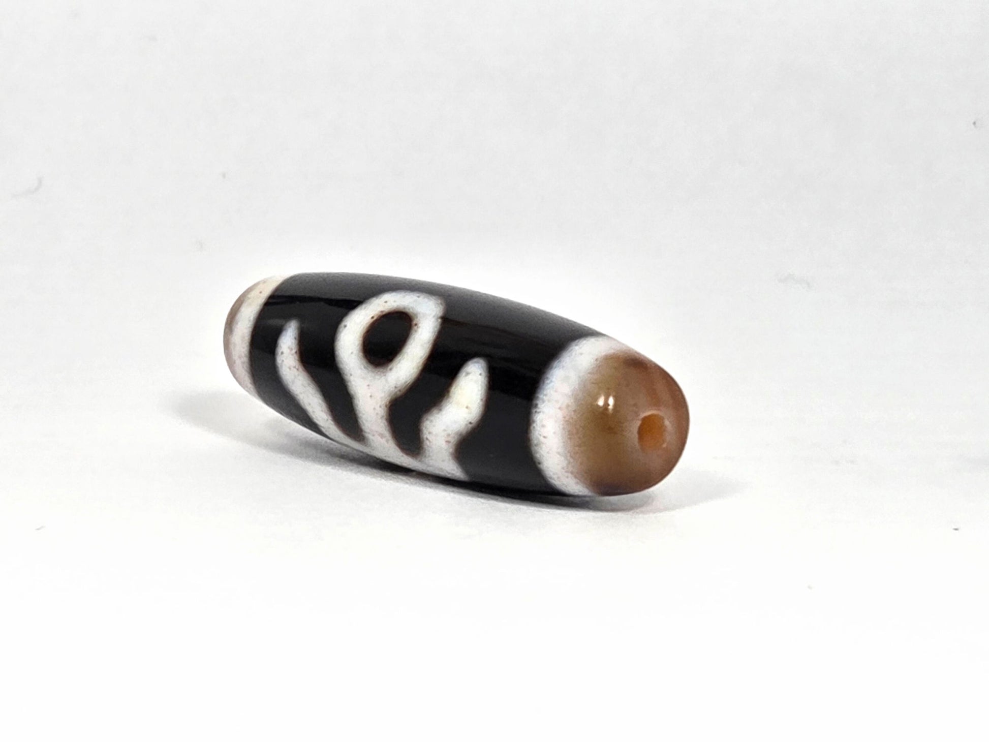 V-090126-BENBS vintage benefactor dzi drill end view one warm honey-brown cap pitch-black unretouched