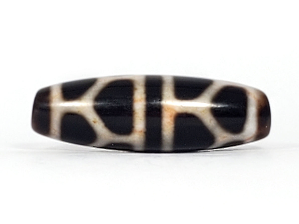 Double longevity dzi bead, pitch-black agate, cream geometric motif, bloodspots, aged patina, oval barrel shape, 38.6mm