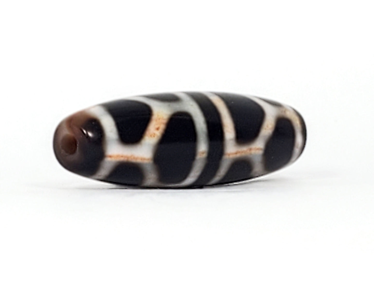 V-092824-DLBS2 Double Longevity dzi bead, angled end view, warm brown drill tip and pitch-black body, unretouched