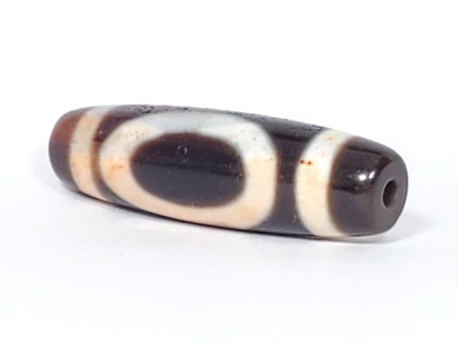 V-082123-HEBS Heaven & Earth dzi bead, angled end view, warm chestnut-brown end cap and drill hole visible, unretouched