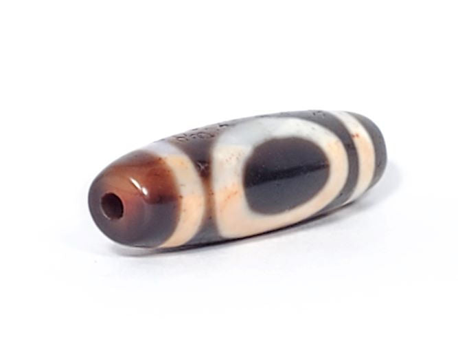 V-082123-HEBS Heaven & Earth dzi bead, opposite angled end view, chestnut-brown cap, dark brown body, Heaven circle face, unretouched