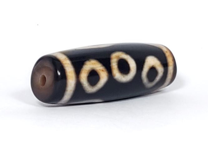 V-102723-6EBS Six Eye dzi bead, opposite angled end view, warm brown cap, pitch-black body, unretouched