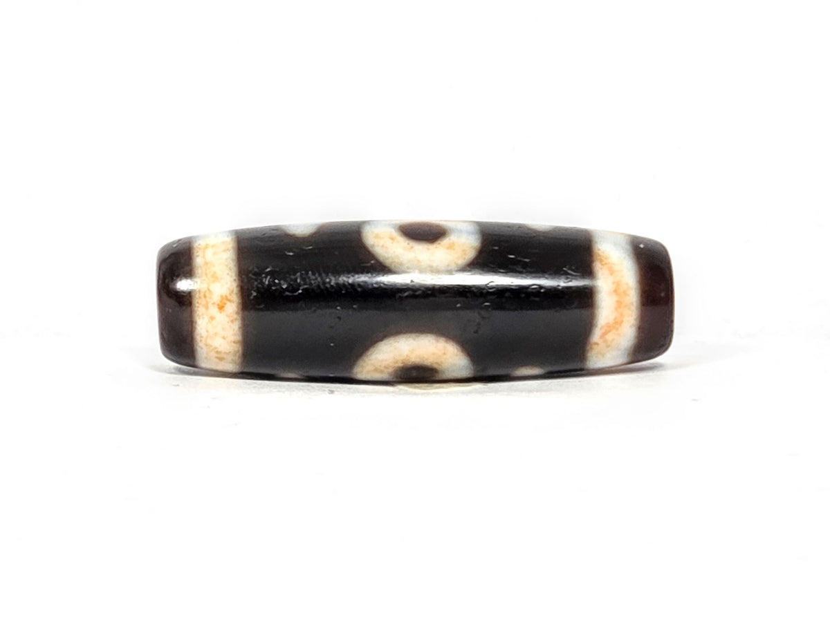 V-021326-BenBS vintage Benefactor dzi bead, second angled end shot, drill hole visible, dark brown end cap, unretouched.